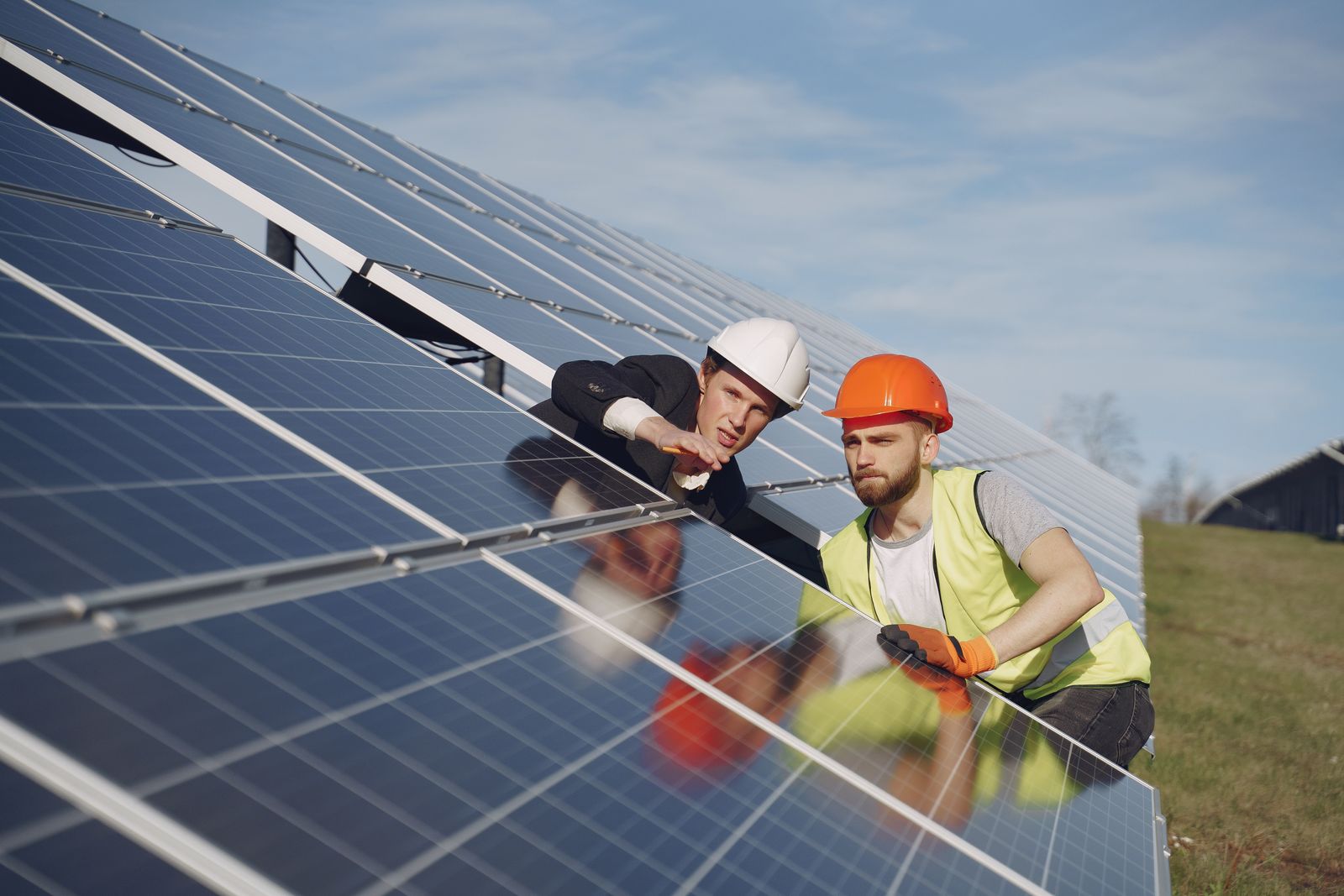 A SunHarvest technician checking string wiring on a commercial rooftop array
